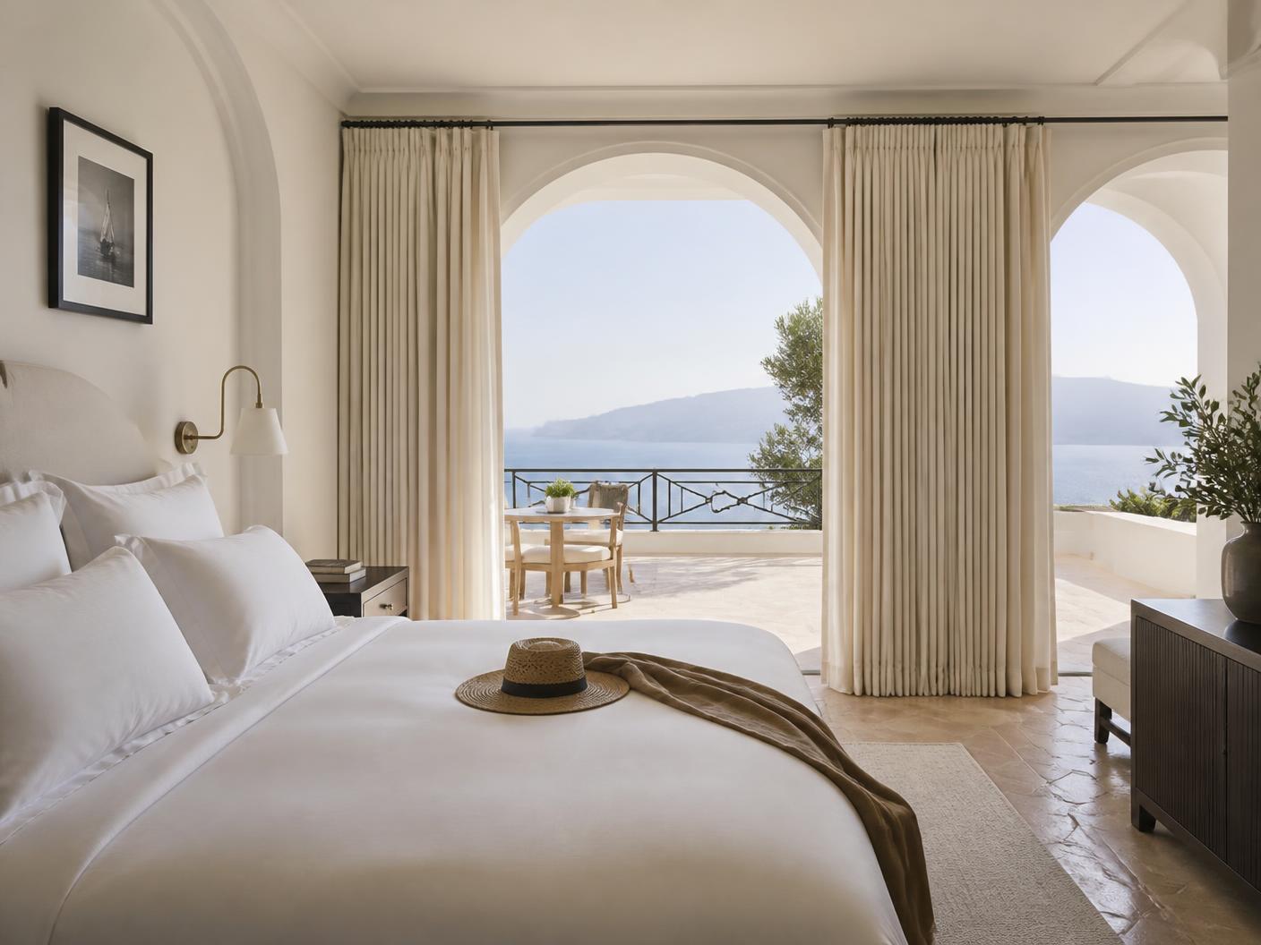 Camera con archi bianchi e terrazza affacciata sul mare
