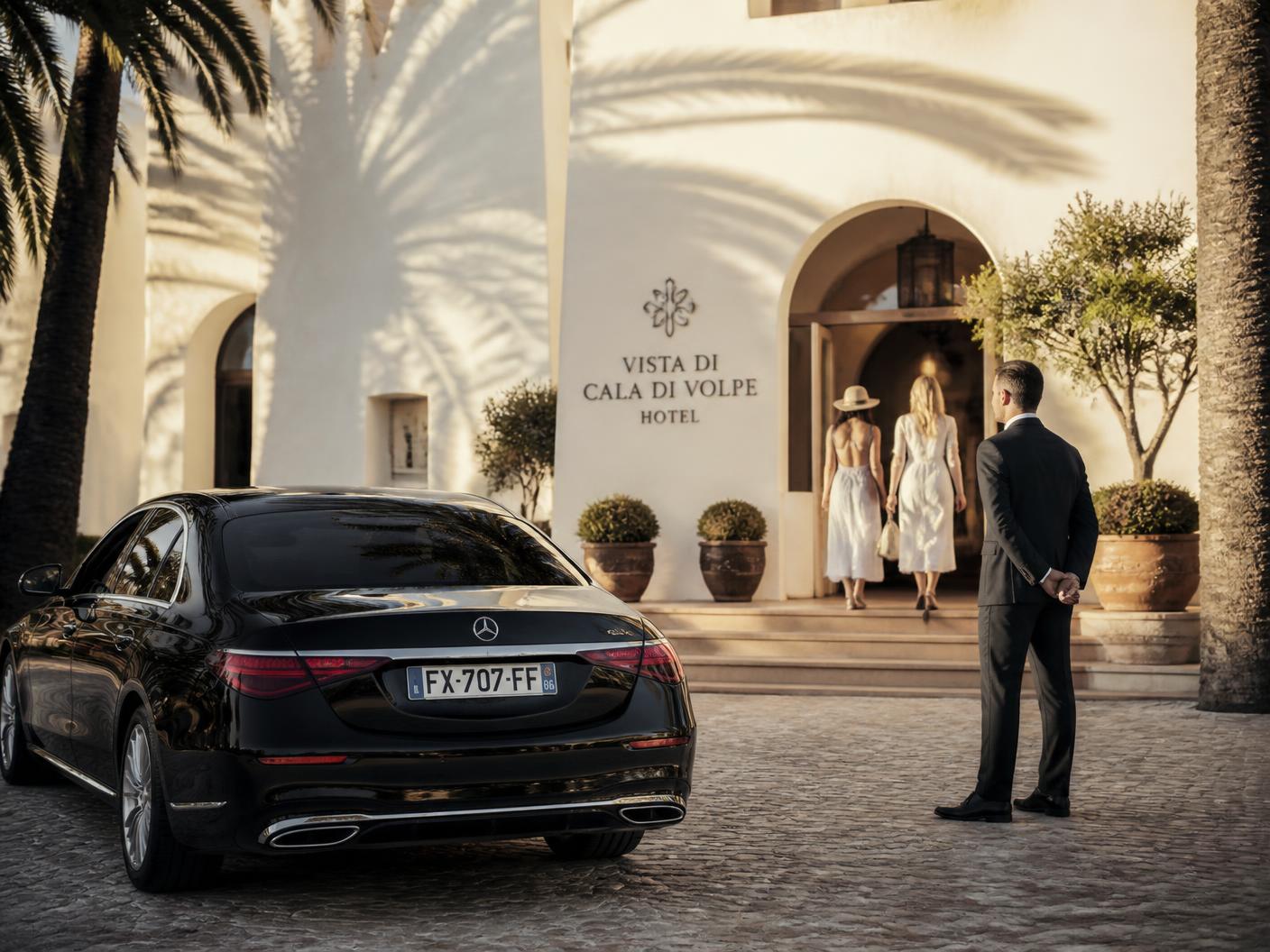 Auto privata in attesa all'ingresso di una struttura mediterranea al tramonto